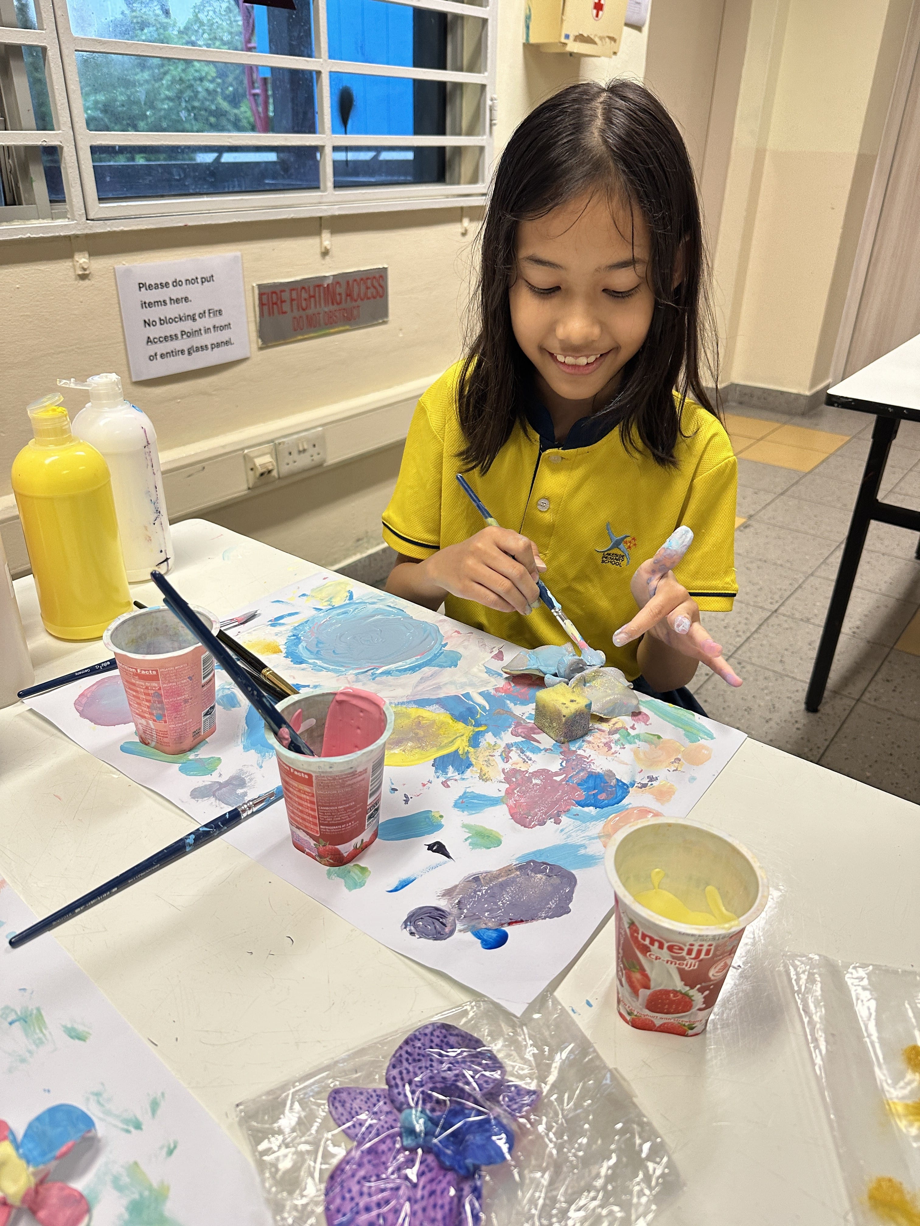 A student from 4 Diligence exploring colours as she paints